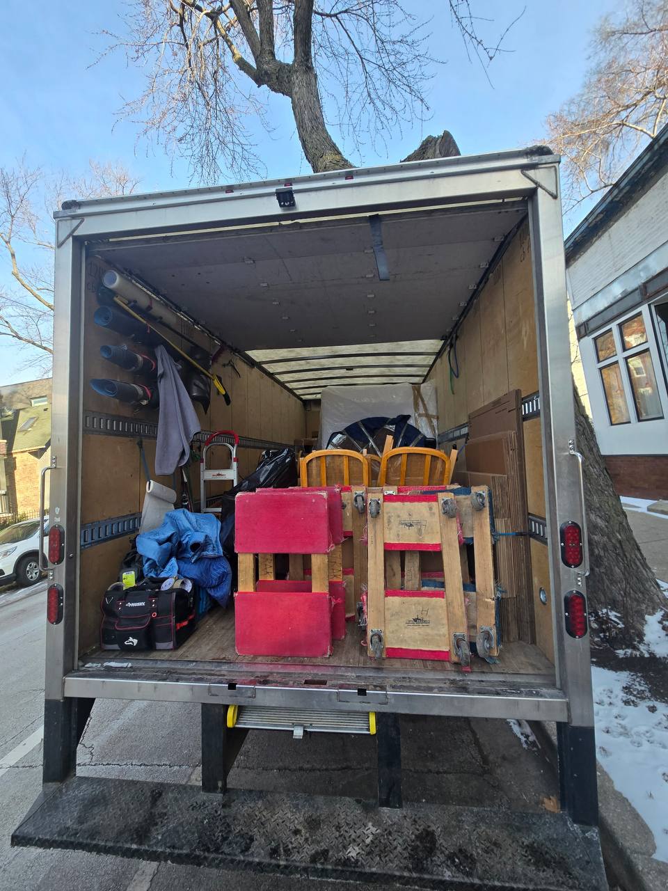 Moving truck with red dollies and equipment